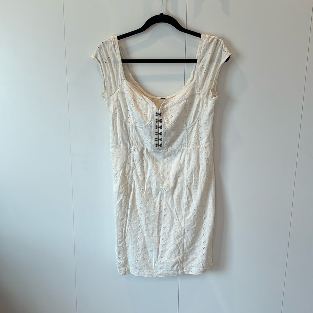 Free People white eyelet mini dress with front hooks.